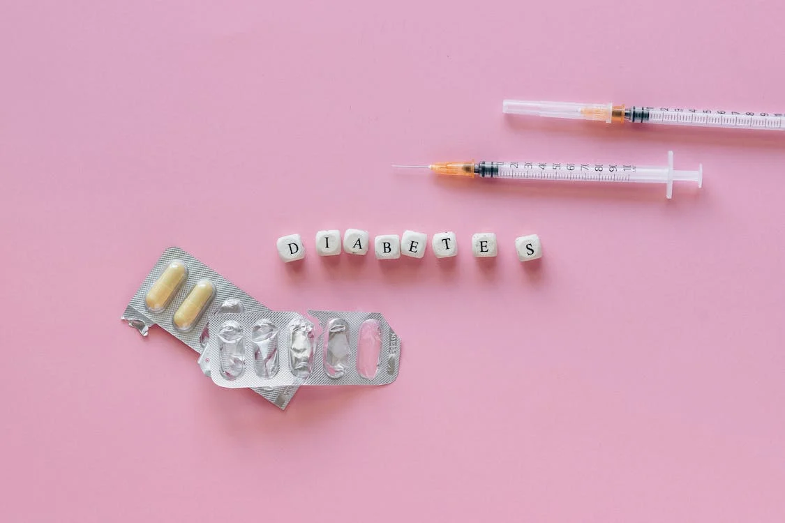 a syringe and pills on a pink background